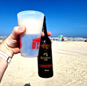 Bouteille de bière Rivière d'Ain sur une plage au Brésil